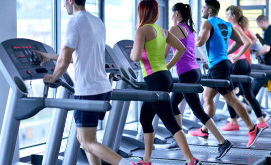 Group of people running on treadmills