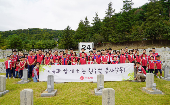 롯데건설 임직원 가족들이 묘역 앞에서 봉사활동